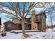 Back view featuring a large stone chimney and a balcony off the second story, with snow covering the deck at 1307 W 161St St, Westfield, IN 46074