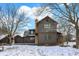 Charming two-story home featuring a stone chimney and wood accents, surrounded by snow-covered landscape and mature trees at 1307 W 161St St, Westfield, IN 46074
