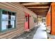 Side porch featuring log walls, green framed windows, and a striking red door at 1307 W 161St St, Westfield, IN 46074