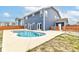 A backyard featuring a blue house, concrete patio, and an inviting kidney-shaped pool, perfect for outdoor relaxation at 1324 Trailside Dr, Greenwood, IN 46143