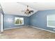 Comfortable blue bedroom featuring plush carpet, two windows, and a ceiling fan at 1324 Trailside Dr, Greenwood, IN 46143