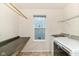 Functional laundry room with countertop, overhead rack, and view of the backyard at 1324 Trailside Dr, Greenwood, IN 46143