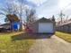 Driveway leading to backyard garage with green siding and white door at 2414 W 16Th St, Anderson, IN 46016