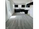 Bright kitchen with black cabinetry, white countertops, and wood-look laminate flooring at 310 S Gerrard Dr, Indianapolis, IN 46241