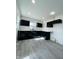 Modern kitchen with black cabinets, white countertop, laminate flooring, and ample natural light at 310 S Gerrard Dr, Indianapolis, IN 46241
