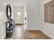 Inviting hallway features wood-look flooring, shiplap accent wall, decorative mirror, and front door at 3783 Sunset Ridge Dr, Franklin, IN 46131