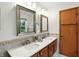 Bright bathroom featuring and sinks, modern lighting, wood cabinets, and two framed mirrors at 4646 Rocky Knob Ln, Indianapolis, IN 46254