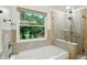 Bathroom featuring a tub, shower, and window with a view of the outdoors at 4646 Rocky Knob Ln, Indianapolis, IN 46254