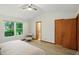 Bright bedroom with hardwood floors, a large window, a ceiling fan, and an open closet door at 4646 Rocky Knob Ln, Indianapolis, IN 46254