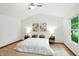 Spacious bedroom featuring a ceiling fan, a large window, and decor-matching bedside lamps and art at 4646 Rocky Knob Ln, Indianapolis, IN 46254