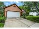 Spacious two-car garage with a concrete driveway and lush landscaping surrounding the property at 4646 Rocky Knob Ln, Indianapolis, IN 46254