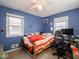 Blue bedroom with a bed, desk, and window at 6004 S Orinoco Ave, Indianapolis, IN 46227