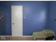 Blue bedroom with a door and a small rug at 6004 S Orinoco Ave, Indianapolis, IN 46227