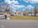 Tan brick ranch house with covered porch, landscaping, and driveway at 6004 S Orinoco Ave, Indianapolis, IN 46227