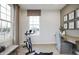 Bright home gym with exercise bike, desk, and large windows at 6345 Stone Side Dr, Plainfield, IN 46168