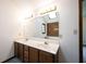 Bathroom with double sinks, vanity, and a large mirror reflecting a window at 8041 Halyard Way, Indianapolis, IN 46236