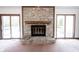 Close-up of the stone fireplace with a wooden mantle, flanked by sliding glass doors at 8041 Halyard Way, Indianapolis, IN 46236