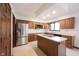 Bright kitchen with stainless steel appliances, a center island, and wooden cabinetry at 8041 Halyard Way, Indianapolis, IN 46236