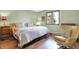 Cozy bedroom with a patterned bedspread, a chair, and a view of a wooded area at 8072 Foxchase Dr, Indianapolis, IN 46256