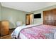 Comfortable bedroom featuring wood floors, a red floral bedspread, a cream colored chair and light green colored walls at 8072 Foxchase Dr, Indianapolis, IN 46256