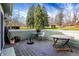 A wooden deck contains tables, chairs, and potted plants, offering a view of the yard at 8072 Foxchase Dr, Indianapolis, IN 46256