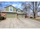 View of the townhomes featuring green siding, brick accents, and attached garages with concrete driveway at 8072 Foxchase Dr, Indianapolis, IN 46256