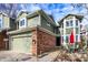 Two-story townhome featuring green siding, brick accents, and a outdoor seating area with a red umbrella at 8072 Foxchase Dr, Indianapolis, IN 46256