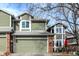 Two-story townhome with a attached garage, brick accents and green siding, complemented by well-kept landscaping at 8072 Foxchase Dr, Indianapolis, IN 46256
