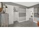 A bedroom with gray and white striped walls, a sliding closet door, and access to another room at 8885 Lowell St, McCordsville, IN 46055