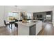 Open concept kitchen with a center island, stainless steel dishwasher, and an adjacent dining and living space at 8885 Lowell St, McCordsville, IN 46055