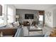 Comfortable living room featuring a gray sofa, accent chair, entertainment center, and large windows at 8885 Lowell St, McCordsville, IN 46055