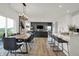 Open concept living space features dining table with seating, living room with sofa and kitchen area at 8885 Lowell St, McCordsville, IN 46055