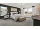 A sun-drenched main bedroom featuring stylish decor, including a statement light fixture and neutral color palette at 8885 Lowell St, McCordsville, IN 46055