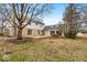 The backyard features a stone and siding facade, a patio, and mature trees, offering a private outdoor space at 9031 Butternut Ct, Indianapolis, IN 46260