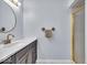 Bathroom with a large round mirror over the sink and a gold-framed shower at 9031 Butternut Ct, Indianapolis, IN 46260