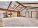 Open living room featuring vaulted ceilings, wood beams, skylights, and access to the backyard at 9031 Butternut Ct, Indianapolis, IN 46260