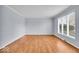 Bright living room with hardwood floors, light blue walls, white trim, and a large window overlooking the front yard at 9031 Butternut Ct, Indianapolis, IN 46260