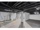 Unfinished basement space with painted walls, exposed pipes, and stairs to the upper level at 916 N Bradley Ave, Indianapolis, IN 46201