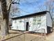House exterior with gray siding, mature trees, and a fenced yard at 9508 Conried Dr, Indianapolis, IN 46235