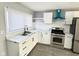Modern kitchen with white cabinets, stainless steel appliances, and marble countertops at 9508 Conried Dr, Indianapolis, IN 46235