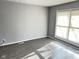 Spacious living room with gray walls, wood-look floors, and large windows at 9508 Conried Dr, Indianapolis, IN 46235