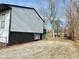 Gravel side yard with chain link fence and mature trees at 9508 Conried Dr, Indianapolis, IN 46235