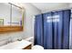 Clean bathroom with blue shower curtain and wood vanity at 1837 E Legrande Ave, Indianapolis, IN 46203