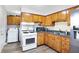 Kitchen with wood cabinets, white appliances, and a double sink at 1837 E Legrande Ave, Indianapolis, IN 46203