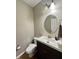 Clean half bathroom featuring a modern vanity with white countertop and round mirror, perfect for guests at 2504 Fawn Bluff Ct, Zionsville, IN 46077
