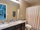Traditional bathroom featuring a double sink vanity with granite counters and neutral-toned shower curtain at 2504 Fawn Bluff Ct, Zionsville, IN 46077