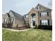 Elegant two-story home with a brick and stone exterior, black shutters, and a well-maintained front lawn at 2504 Fawn Bluff Ct, Zionsville, IN 46077
