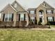 Charming two-story home featuring a brick and stone facade, black shutters, and manicured landscaping at 2504 Fawn Bluff Ct, Zionsville, IN 46077