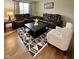 Inviting living room featuring dark leather couches and a decorative rug, perfect for relaxing and entertaining at 2504 Fawn Bluff Ct, Zionsville, IN 46077