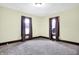 This bedroom features neutral carpet, tan walls, and wood trim around the windows and floors at 403 Colescott St, Shelbyville, IN 46176